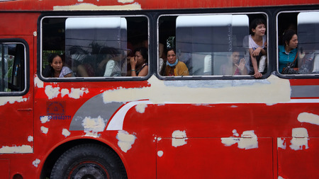 MEKONG DELTA, VIETNAM- JULY 8  Red passenger car transport people stop on street, person stick head out of window and looking, old car transfer passenger on the trip to travel, Viet Nam, July 8, 2014のeditorial素材