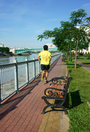 HO CHI MINH, VIETNAM-  AUG 10  People take physical exercise on the riverside park, young man jogging along Saigon river, fresh air in morning, healthy lifestyle for health, Viet Nam,  August 10, 2014のeditorial素材