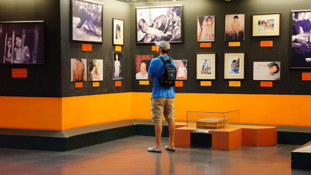HO CHI MINH , VIETNAM- AUG 12   Tourist visit Vietnam War Remnant Museum, people looking photo of agent orange victim, consequence of war, exhibition room in orange color, Vietnam, Aug 12, 2014のeditorial素材