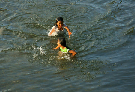 KHANH HOA, VIET NAM- FEB 5: Lifestyle of Vietnamese country children, group of Asian girl bath on river, they swim, splash water, laugh with friend in summer, Vietnam, Feb 5, 2013のeditorial素材