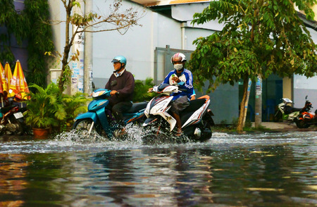 HO CHI MINH CITY, VIET NAM- OCT 9: Hard to circulate situation at Ho Chi Minh city when flood tide, flooded water on street, vehicle traffic in water, danger, unsafe scene, Vietnam, Oct 9, 2014のeditorial素材