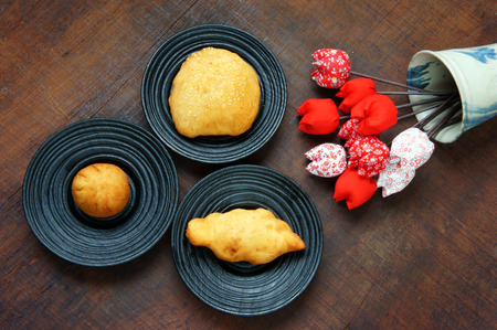 Group of Vietnam street food: fried dumpling, quai vac cake, sponge cake make from wheat flour, good decoration on plate, wooden background, this Vietnamese snack is fastfood, rich cholestorolの写真素材