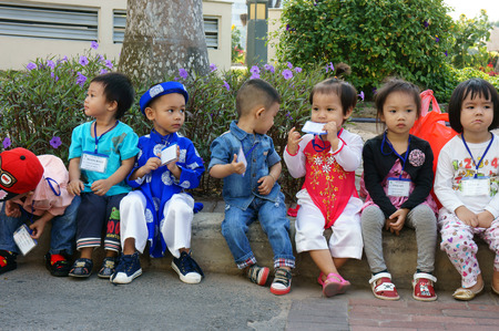 HO CHI MINH CITY, VIET NAM- FEB12: Group of unidentified Asian kid with outdoor activity of preschool, little boy, girl in uniform, Vietnamese children visit park in springtime, Vietnam, Feb 12, 2015のeditorial素材
