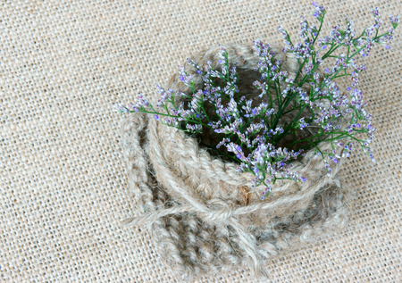 Amazing idea to decor by handmade product, flower pot, heart shape knitted from rope, beautiful flower on burlap background, use valentine day, or thank you idea, vintage styleの写真素材