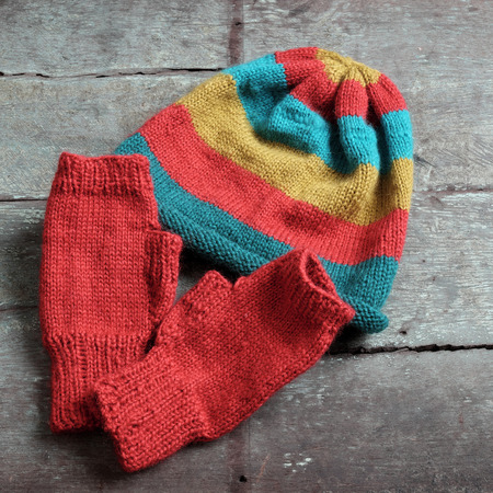 Handmade gift for winter, knitted gloves and knit hat for cold day, group of colorful yarn make warm, knit accessories is hobby activity of womanの写真素材