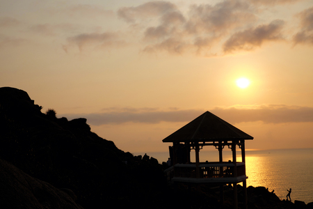 Silhouette of watch tower and people in morning at Dai Lanh cape, Mui Dien, Phu Yen, Viet Nam, yellow sun in sunrise make beautiful scene, this place catch the first sunlight in Vietnam countryの写真素材