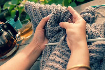 Knit man scarf for cold day in winter, hobby leisure with handmade gift for father day, woman hand knitting from yarn, nice present in vintage colorの写真素材