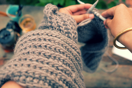 Knit man scarf for cold day in winter, hobby leisure with handmade gift for father day, woman hand knitting from yarn, nice present in vintage colorの写真素材