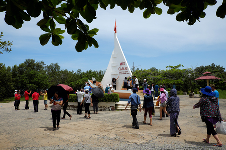 CA MAU, VIET NAM- JULY 16, 2016: Group of tourist travelling Dat Mui, a geography place people walking on breakwater along the beachのeditorial素材