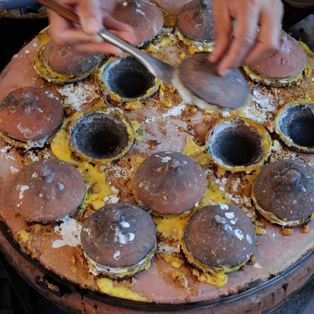 Vietnamese street food, banh can is one of pancake with egg, fish, mango, a famous Vietnam dish at Lien Huong, Binh Thuan, cake process from rice flourの写真素材