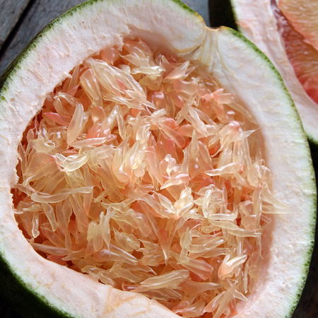 Grapefruit on wood background, tropical fruit, Vietnamese agriculture product, rich vitamin A, healthy eating, reduce cholesterol, prevent kidney stones, oxidation, anti cancer, make lose weightの写真素材