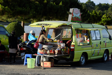 DA LAT, VIET NAM- DEC 27, 2016: Vietnamese vendor sell street food with store from car near Xuan Huong lake on spring day at Dalat, Vietnamのeditorial素材