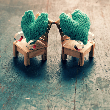 Two hearts be together, illustration for couple in love, take care and loving, green heart on handmade mini furniture as chair, swing, bed on wood backgroundの写真素材
