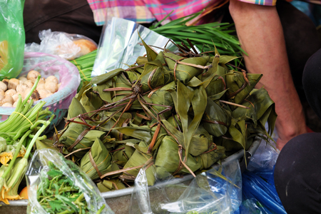 Vietnamese traditional food for may 5th, is double five festival or tet doan ngo, group of sticky rice cake in green leaf, also call banh u tro with pyramidal shape at open air marketの写真素材