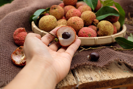 Close up of litchi fruit or lychee fruits, a tropical agriculture product at Luc Ngan, Bac Giang, Vietnam, basket of Vai thieu on brown backgroundの写真素材