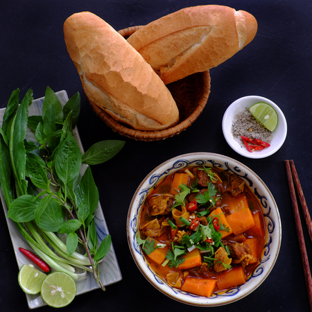 Vietnam food, bread with stewed beef, a popular meal at morning, eat attach parsley, basil, lemon pepper and salt make so delicious tasteの写真素材