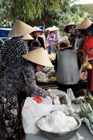 BINH DINH, VIET NAM- NOV 2, 2017: Group of Vietnamese woman purchase at outdoor farmer market at Vietnam countryside, traditional market at morning, food on ground of roadsideのeditorial素材