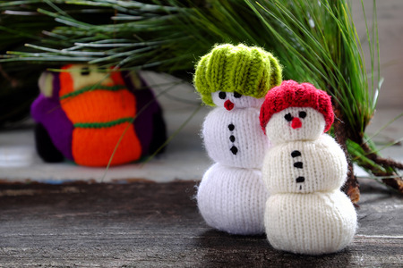 car transport pine tree for Xmas decoration, knitted colorful cars on wooden, two snowman standing beside make funny Christmas backgroundの写真素材