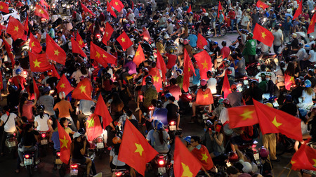 HO CHI MINH CITY, VIET NAM- JAN 24, 2018: Crowd of Vietnamese football fans down the road to celebrate the win after soccer between U23 Vietnam and U23 Qatar, high view with red flag from supporterのeditorial素材