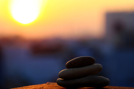 Amazing shape of stack of pebble on yellow sun background at sunrise, three stones balance make...