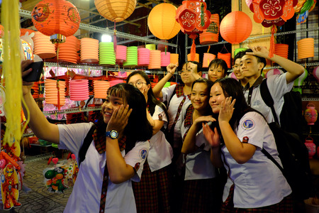 HO CHI MINH CITY, VIETNAM- SEPT 24, 2018: Group of Vietnamese pupils enjoy with friend and selfie by smartphone at outdoor lantern street , Vietnamのeditorial素材