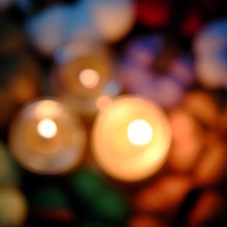 Beautiful colorful background with three candles and group of multicolor pumpkin, blur background by...