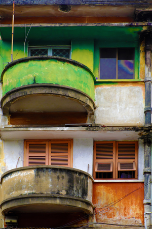 Amazing facade building with contrast color is green and red, antique flat with old architecture at Ho Chi Minh city, Vietnam, vintage wooden window and balcony round from houseの写真素材