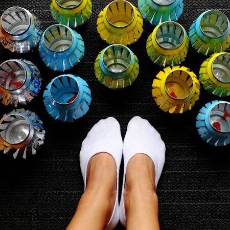 Woman feet in white socks and group of colorful handmade lanterns recycling from beer cans, a home activity at free time in summer dayの写真素材