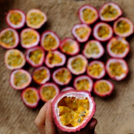 Top view passion fruits cut in half in heart shape background, kind of seedy fruit or passiflora...