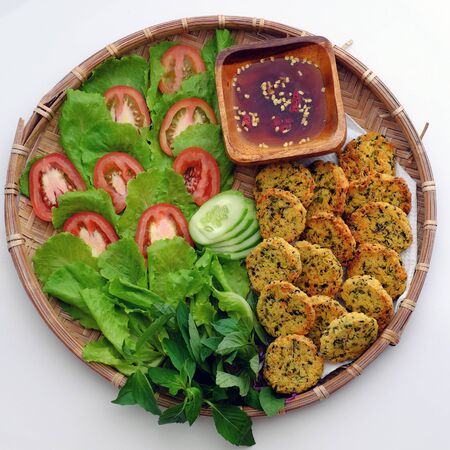 Top view tray of Vietnamese vegan food, green bean pies with salad, tomato and sauce, savory dish for vegetarian meal, snack or breakfastの写真素材