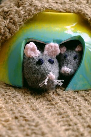 Funny concept for rat year, couple mouse animal warm in mice cave that recycle from broken bowl on burlap background, handmade toy animals knit from yarnの写真素材