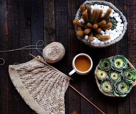 Top view coffee cup, basket of green rose for home morning coffee time, ball of yarn for knit at on black wooden backgroundの写真素材