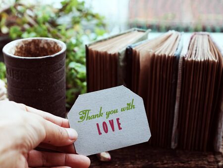 Thank you concept with group kraft paper notebook and writing message on piece of paper, green plant...