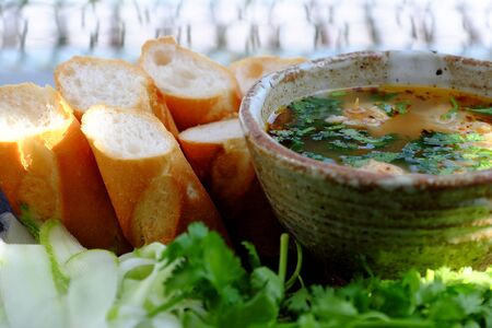 Delicious meal for breakfast, bowl of vegan meatballs soup eat with bread, cilantro leaves, cucumber, vegetarian dish from tofu for healthy eatingの写真素材