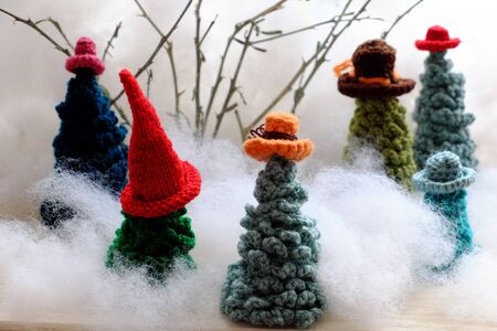 Group of green Christmas tree wear colorful hat crochet from yarn to make handmade ornament for...