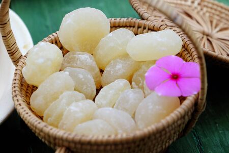 Vietnamese traditional food for tet from vegetables, close up homemade sweet water chestnut jam in white in basket on bamboo background for tea time at spring seasonalの写真素材