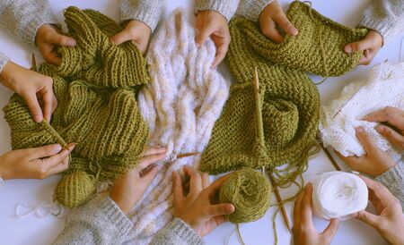 Amazing scene from indoor top view, group of woman hand with knitting needles to knit wool white and...