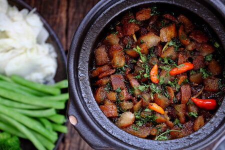 Top view Vietnamese meal for lunch of vegetarian, plate of boiled vegetables and vegan braised sauce in pot, delicious dish ready to eat with rice, healthy simple daily meal on dark wooden backgroundの写真素材