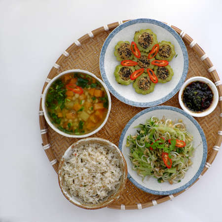 Top view tray of daily meal with dieting menu from vegan food, nutrition and healthy dish with stuffed bitter melon with tofu, potato and corn soup, fried chayote and bean sproutsの写真素材