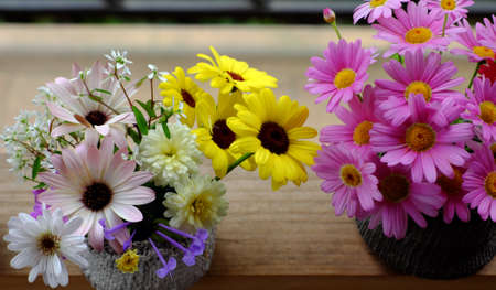 Beautiful colorful flower arrangement for decor inside home, variety tiny daisy just cut from home garden to make wonderful space in spring time, vase of flowers ready to decoration on woodenの写真素材