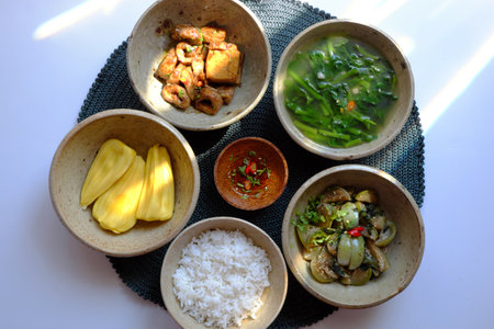 Top view tray of Vietnamese vegan food, rice bowl, fried aubergine, seitan cook with sauce, spinach soup, non meat diet menu for daily family meal good for healthの写真素材