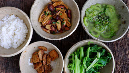 Frugal meal with vegetarian food, jackfruit and tofu skin cook with sauce, boiled vegetable, bitter melon soup, top view healthy tray for food on white for lunchの写真素材