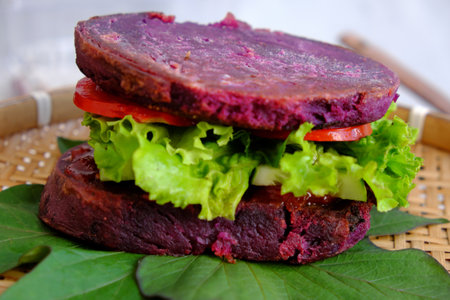Amazing vegan hamburger from violet sweet potato with tomato, salad, healthy food for breakfast that rich starch, fiberの写真素材