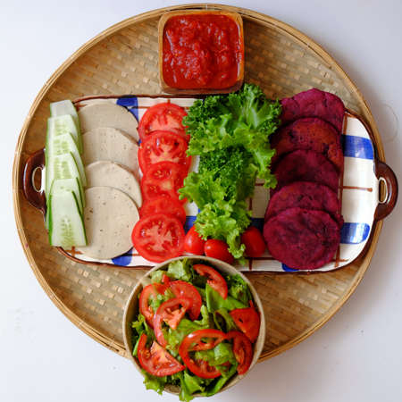Amazing colorful raw material food for vegan hamburger from violet sweet potato with tomato sauce, salad, cucumber, healthy food for breakfast that rich starch, fiberの写真素材