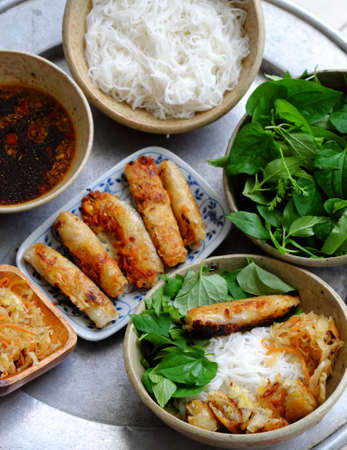 Top view tray of Vietnamese food for daily family meal weekend, fried spring roll rice noodles with lettuce and basil leaf and soy sauce, vegan dish good for healthy by non meat menuの写真素材