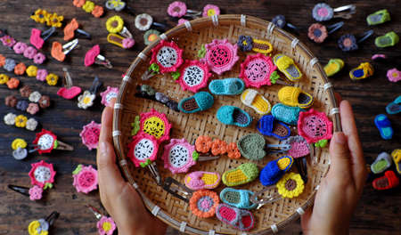 Top view Vietnamese woman hand hold handmade product, crochet hair pin in many shape and colorful, pretty handcraft gift accessories for beauty on black backgroundの写真素材