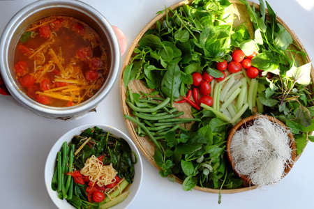 Top view Vietnamese vegan food, green vegetables hot pot homemade from tomato, soy protein, chili sate, amaranth, pepper elder, bun, spinach, healthy eating that rich fiber, vitamin for vegetarianの写真素材
