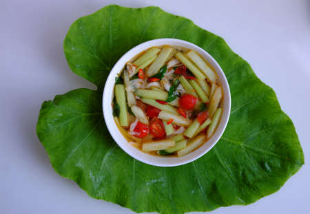 Top view Vietnamese vegan food for lunch meal, tomato soup bowl cook with ripe tamarind, colocasia gigantea and basil leaf, simple dish but delicious homemade eatingの写真素材