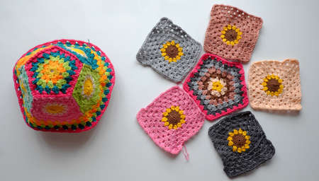 Top view handmade product to make spring present, colorful bucket hat with many piece link together, cute crochet hat from yarn on white backgroundの写真素材