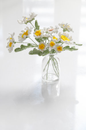 Amazing handmade flower pot for home decor, white petal daisy and yellow pistil crochet from yarn at leisure activities on white backgroundの写真素材